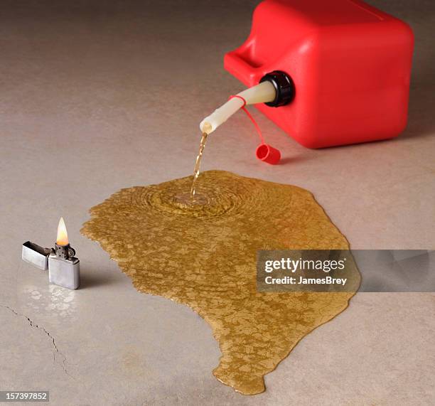 danger; tipped red gasoline can spilling with fire near - libya petrol stock pictures, royalty-free photos & images