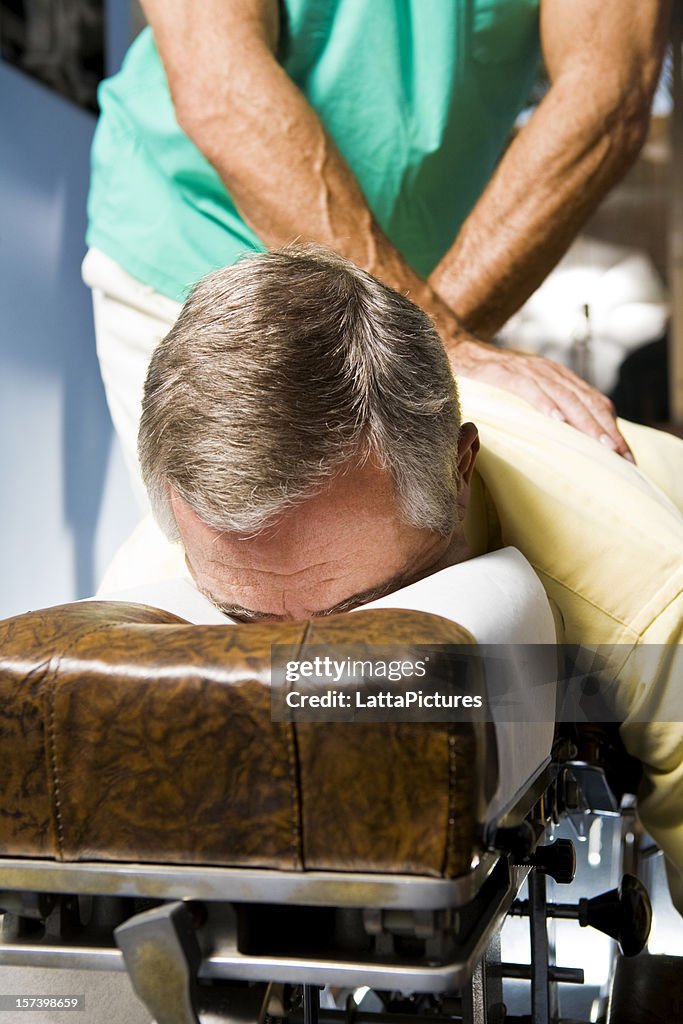 Senior homme allongé tête baissée dans'ajustement chiropratique lit