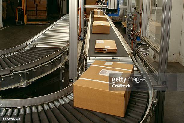 conveyor belt curve showing brown packed postal boxes - belt stock pictures, royalty-free photos & images