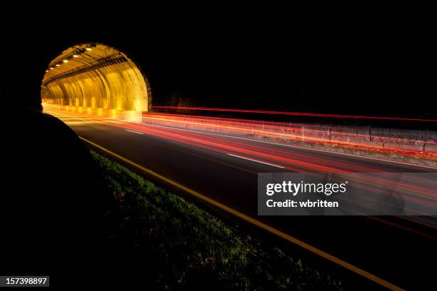 le tunnel dans la nuit avec les lumières floues voiture - tunnel routier photos et images de collection