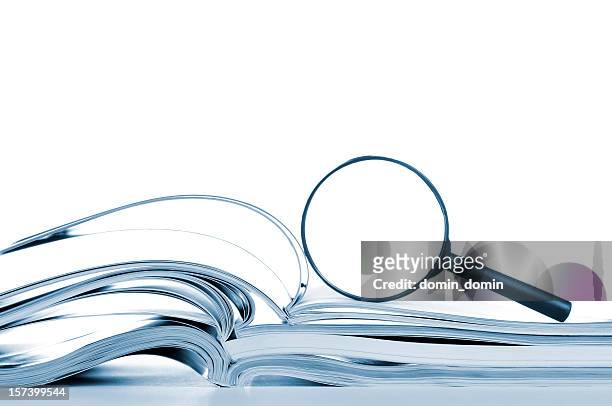 searching, opened magazines and magnifier glass, side view, isolated white - vergrootglas stockfoto's en -beelden