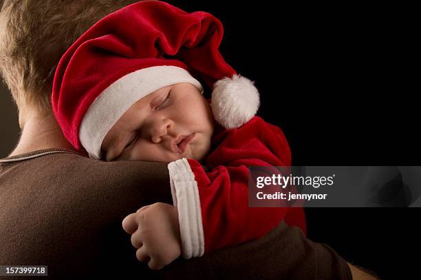 a baby dressed in christmas clothes while sleeping on father - santa dad stock pictures, royalty-free photos & images