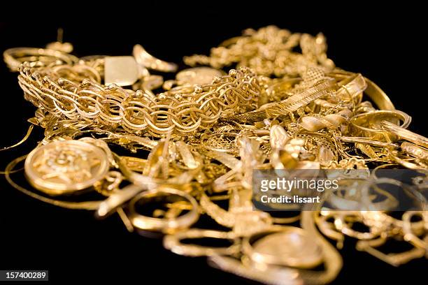 several pieces of gold jewelry in a pile - gold jewellery stock pictures, royalty-free photos & images