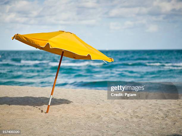 sunchairs and umbrella on beach - yellow umbrella stock pictures, royalty-free photos & images