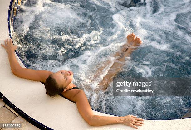 woman relaxing in an outdoor hot tub - hot tub stock pictures, royalty-free photos & images