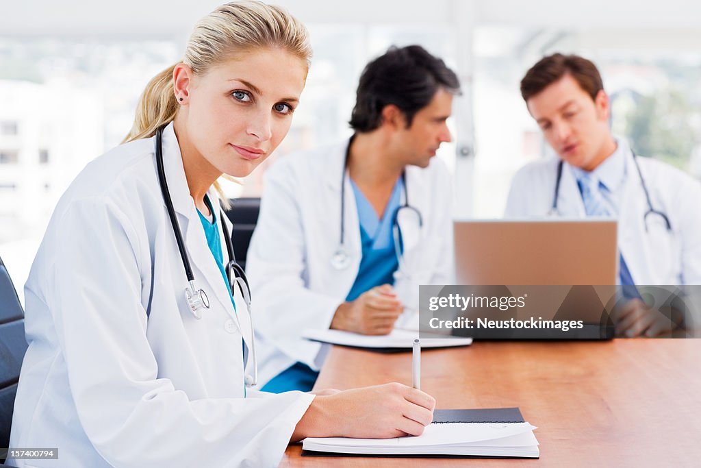 Female doctor with colleagues in the background