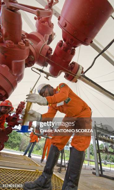 Petrobras worker checks the oil pressure of one of the pipes at the RUC063 oil well, part of the Urucu oilfield, 650 Km southeast of Manaus, Brazil,...