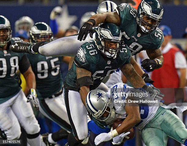 Trent Cole and Akeem Jordan of the Philadelphia Eagles tackle DeMarco Murray of the Dallas Cowboys at Cowboys Stadium on December 2, 2012 in...