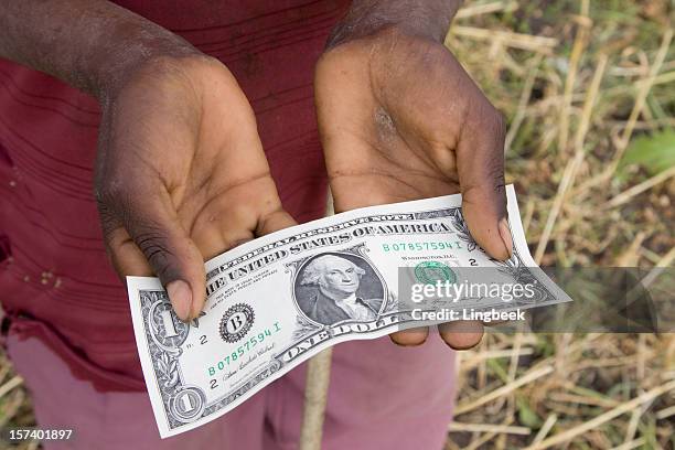 menino africano segurando um dólar canadense - trabalho infantil imagens e fotografias de stock