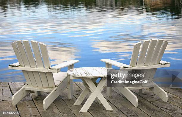 two white adirondack chairs - adirondack chair stockfoto's en -beelden