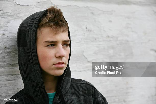 teen boy mit hoodie vor alte weiße mauer - boy thinking stock-fotos und bilder