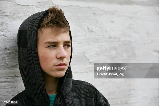 teen boy with hoodie in front of old white wall - boys stock pictures, royalty-free photos & images