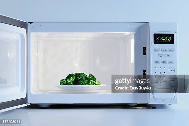 a small plate of broccoli inside a microwave - microwave oven stock pictures, royalty-free photos & images