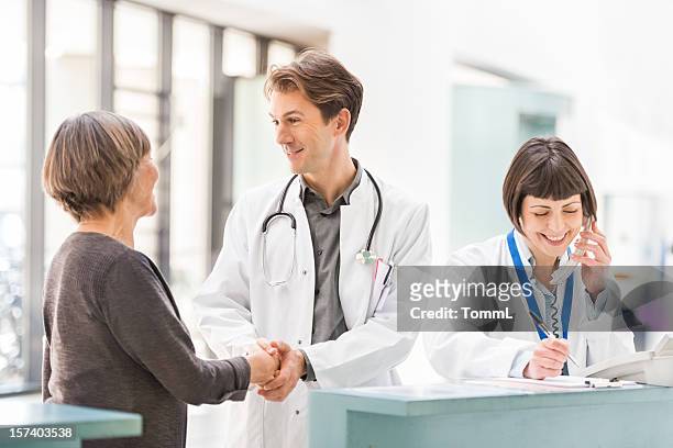 doctors and patient at reception desk - wedding reception stock pictures, royalty-free photos & images