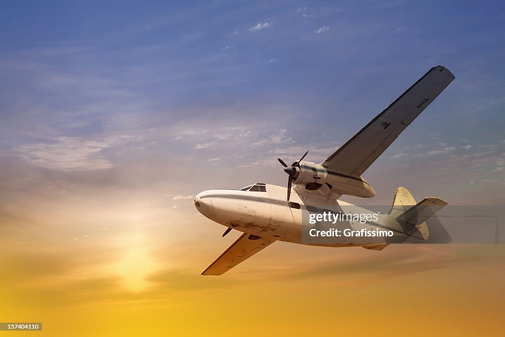 Antique propeller airplane at sunset