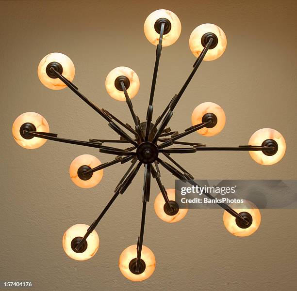 looking up at wrought iron chandelier with twelve lamps - fitting stockfoto's en -beelden