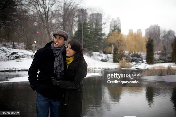 beautiful young couple walking in snowy central park, copy space - couple central park stockfoto's en -beelden