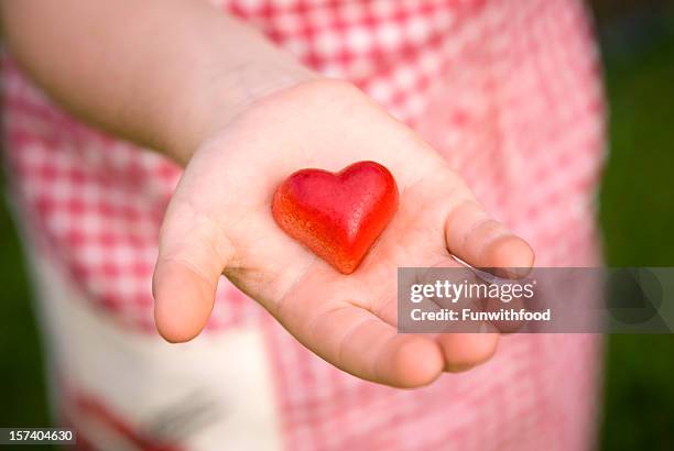 child giving heart valentine's day food, hand holding chocolate candy - truffles stock pictures, royalty-free photos & images