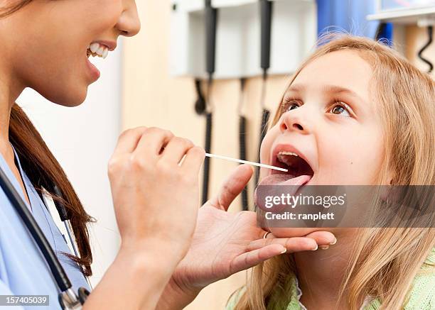 visiting the doctor - girl tongue doctor stockfoto's en -beelden