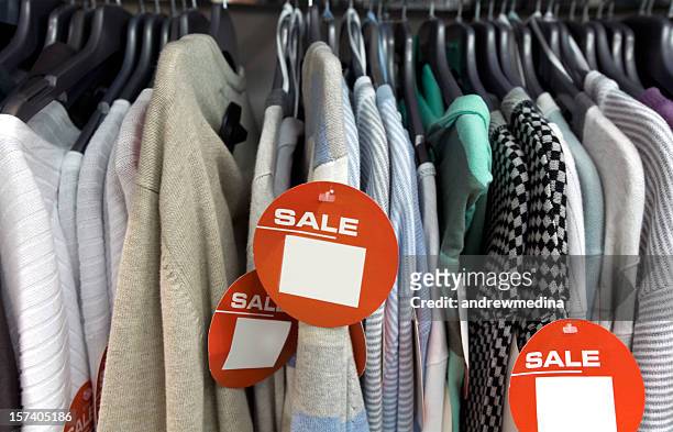 saldi-abbigliamento fare clic per più vuoto segni e avvisi - clothes hanging on rack at store for sale foto e immagini stock