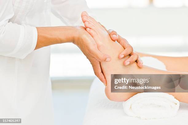 lady recieving foot massage at spa - pedicure stockfoto's en -beelden