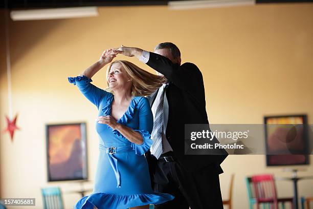 mature couple happily ballroom dancing indoors - ballroom stockfoto's en -beelden