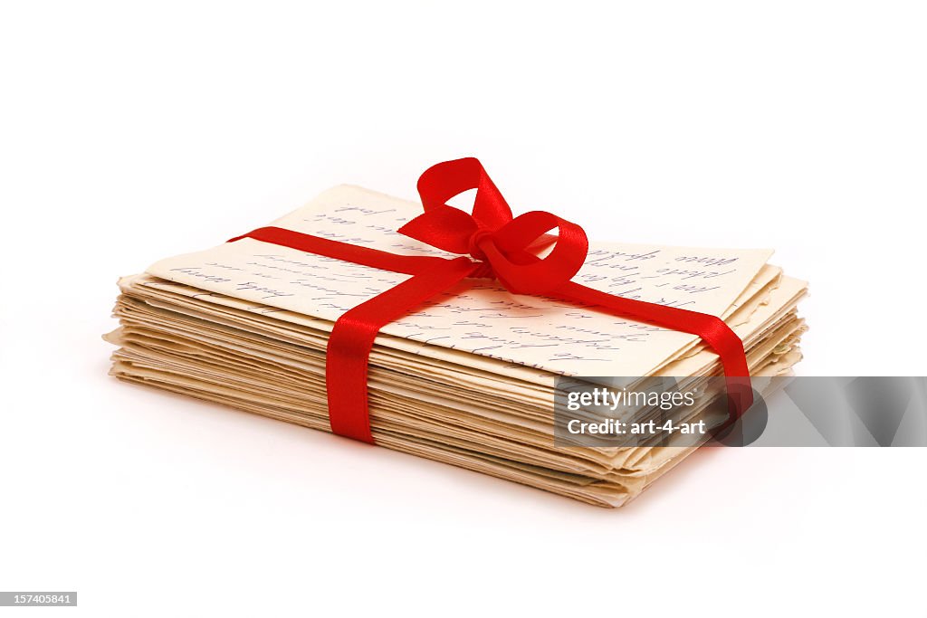 Stack of old love letters bonded with red ribbon