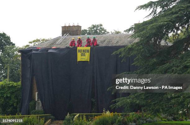 Greenpeace activists on the roof of Prime Minister Rishi Sunak's house in Richmond, North Yorkshire after covering it in black fabric in protest at...