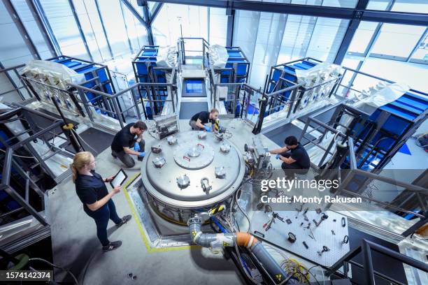 scientists checking large pulsed power machine which creates nuclear fusion in nuclear fusion research facility - nuclear fusion stock-fotos und bilder