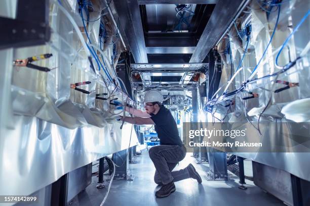 engineer working on capacitors of pulsed power machine in nuclear fusion research facility - kernfusie stockfoto's en -beelden