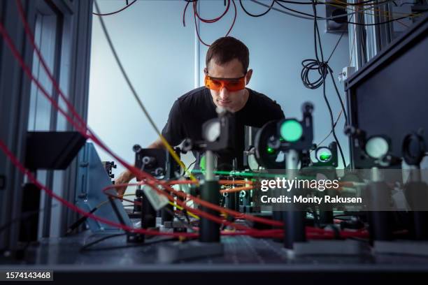 scientist preparing laser for fusion shot in nuclear fusion research facility - kernfusie stockfoto's en -beelden