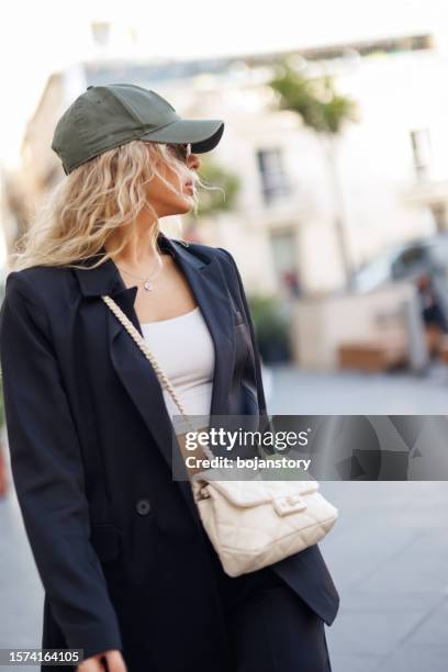 fashionable young woman walking in the city - keps bildbanksfoton och bilder