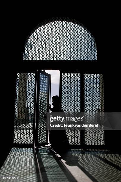 lady in veil entering a transparent door - arab woman silhouette stock pictures, royalty-free photos & images