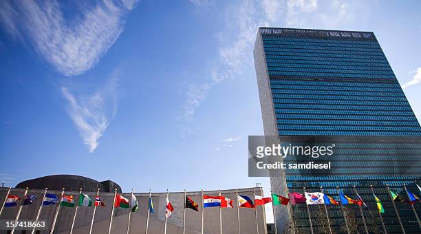 bâtiment des nations unies et drapeaux - drapeau des nations unies photos et images de collection
