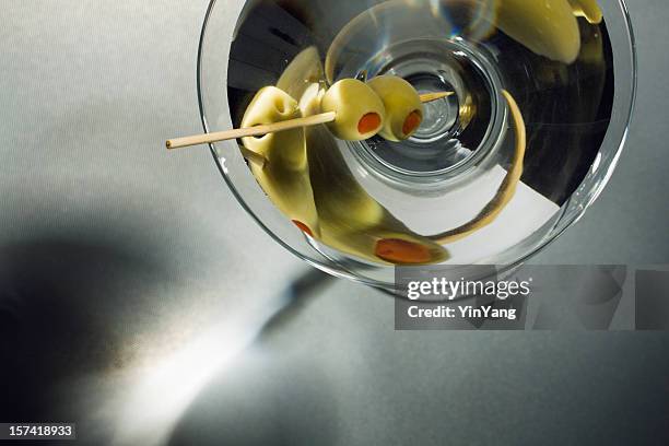 martini glass cocktail drink withtoothpick skewered  olives overhead view - martini stockfoto's en -beelden