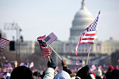 A grip of people holding flags in front of the White House