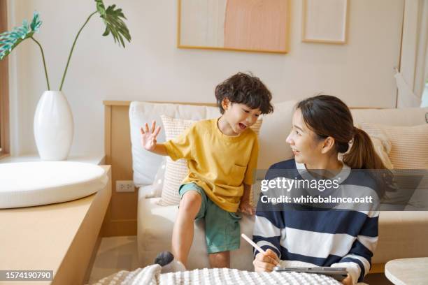 single mother spending time with her son while staying at home. - liberty mutual insurance stock pictures, royalty-free photos & images