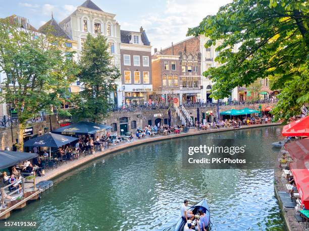 touristes assis dehors dans des restaurants sur le quai le long d’oudegracht, utrecht, pays-bas - utrecht photos et images de collection