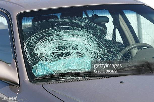 broken windshield on a grey car - voorruit stockfoto's en -beelden
