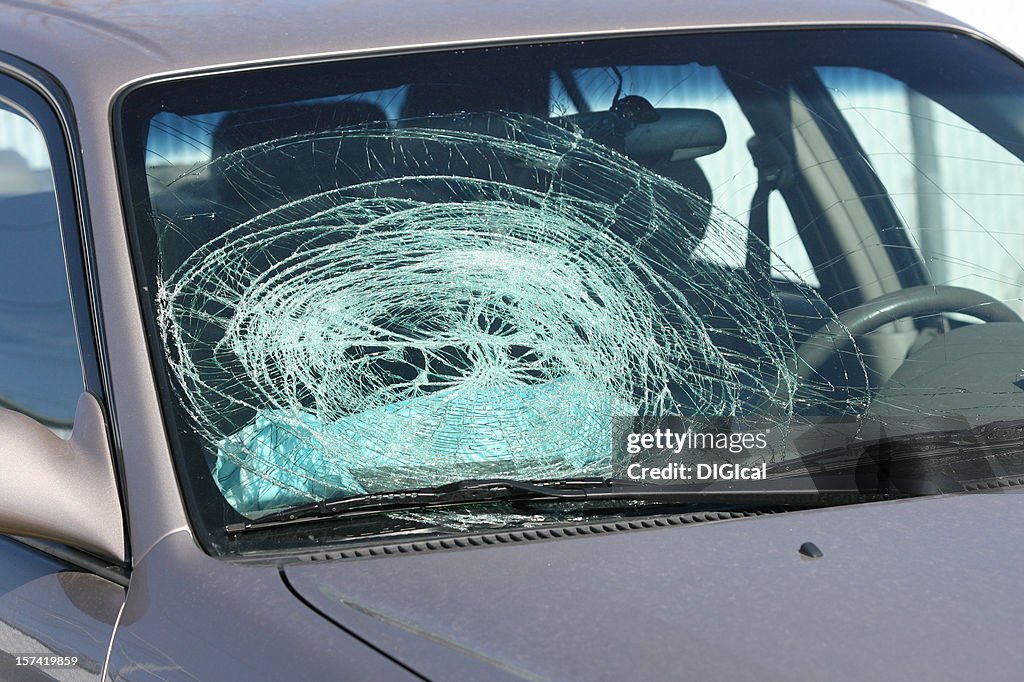 Broken windshield on a grey car