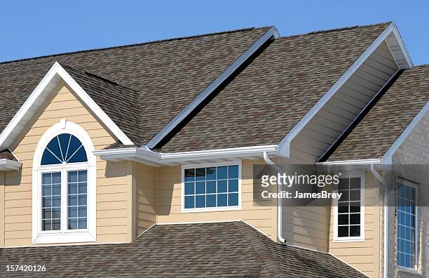 new residential house; architectural asphalt shingle roof, vinyl siding, gables - dak stockfoto's en -beelden