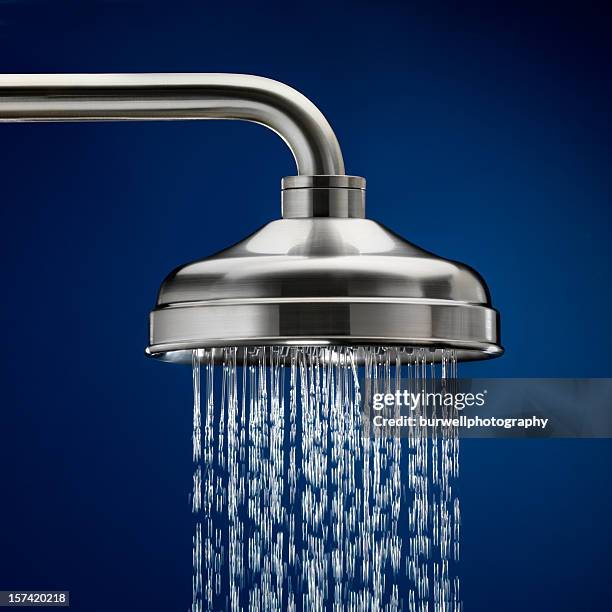 shower head with streaming water, blue background - 廁所 家居設施 個照片及圖片檔