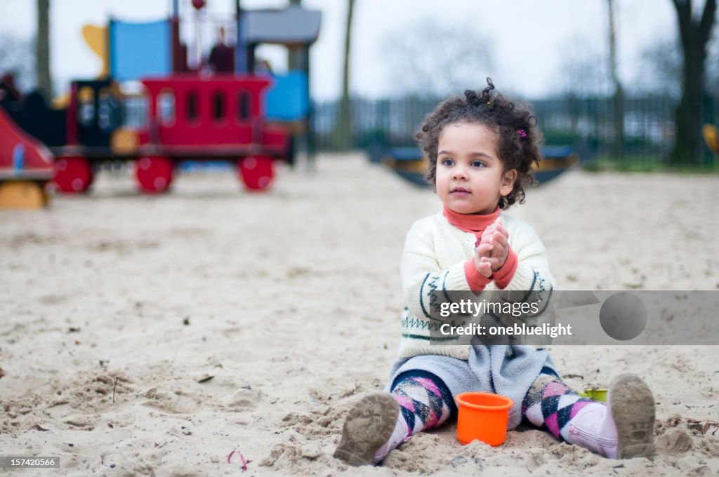 Criança brincando na areia Poço