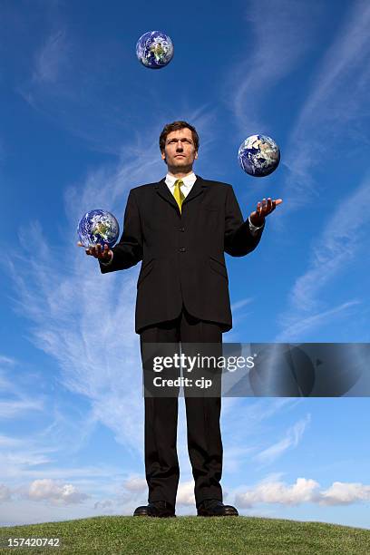 businessman juggling with earth globes - man with big balls stock pictures, royalty-free photos & images