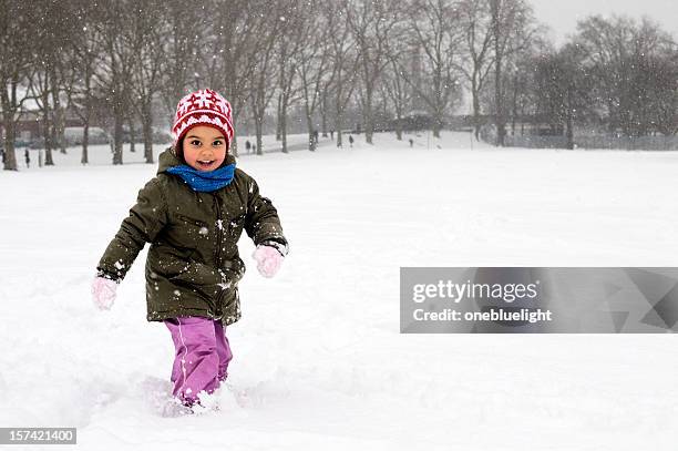 a little girl running in the winter snow - toddler snow stock pictures, royalty-free photos & images