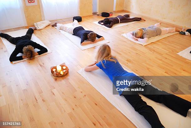 yoga training group on floor - shakra stock pictures, royalty-free photos & images