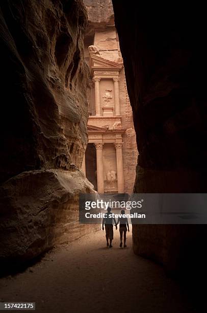 Two figures approach the lost city of Petra