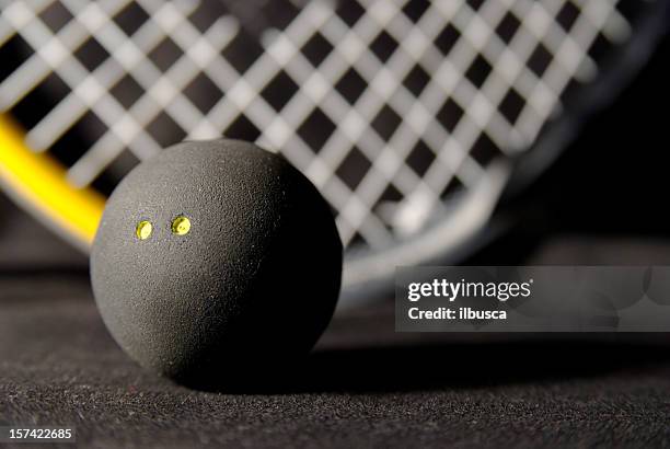 squash ball und schläger auf schwarz - squash racquet stock-fotos und bilder