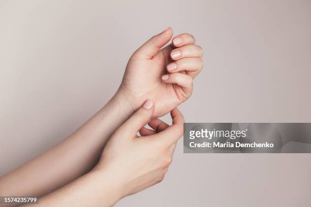 hands with beautiful manicure - pink gel nails - huidkleurig stockfoto's en -beelden