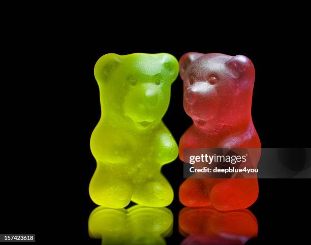 gummy bear couple close up isolated on black - gummi bears stockfoto's en -beelden